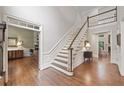 Grand staircase with hardwood floors and a view to the living room at 120 Forest Breeze Cv, Alpharetta, GA 30022
