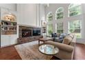 Bright and spacious living room with a stone fireplace, large windows, and hardwood floors at 1055 Beacon Hill Xing, Alpharetta, GA 30005