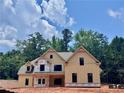 Two-story home featuring a gable roof design, light yellow siding, black trim, and a double-door entry at 133 West Lake Blvd, Carrollton, GA 30116