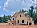 Two-story home with an attached two-car garage and light yellow siding with a gable roof design at 133 West Lake Blvd, Carrollton, GA 30116