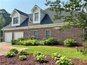 Charming brick home featuring manicured lawn and two-car garage with dormer windows at 3753 Honey Pot Ne Way, Marietta, GA 30066