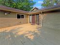 A view of the house entrance from a large deck with wooden flooring at 3985 Loch Highland Ne Pass, Roswell, GA 30075