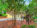 View of house exterior with a driveway surrounded by trees and other landscaping at 3985 Loch Highland Ne Pass, Roswell, GA 30075