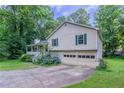 Home exterior features a two-car garage, beautiful greenery, and a well-maintained lawn at 2140 Deer Trl, Suwanee, GA 30024