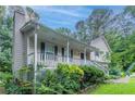 Charming home with a covered front porch, green shutters, and lush landscaping at 2140 Deer Trl, Suwanee, GA 30024