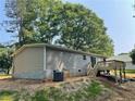 Back exterior of home featuring a small deck, neutral siding, and backyard access at 921 Marshall Fuller Rd, Dallas, GA 30157