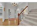 Bright foyer with hardwood floors, staircase, and a front door view creating an inviting entryway at 305 River Glen Dr, Roswell, GA 30075