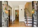 Inviting foyer with hardwood floors, decorative wreaths on the french doors, and a staircase leading to the second floor at 3453 Drayton Ne Dr, Roswell, GA 30075