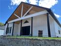 Covered porch with black columns, a vaulted wood ceiling, and white trim, set against a sunny sky at 520 Rockbridge Rd, Lilburn, GA 30047