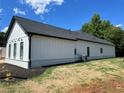 Exterior shot showcasing white vertical siding with black trim and dark roof on a sunny day at 520 Rockbridge Rd, Lilburn, GA 30047