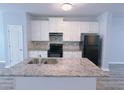 Well-equipped kitchen with granite countertops, white cabinets, and black appliances at 1892 Old Dogwood, Jonesboro, GA 30238