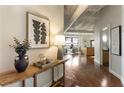 Inviting hallway with hardwood floors, decor, and a view into the living room and kitchen at 878 Peachtree Ne St # 704, Atlanta, GA 30309