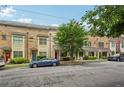 Street view of brick townhouses featuring manicured front yards, covered porches, and shade trees at 190 Marion Ne Pl, Atlanta, GA 30307