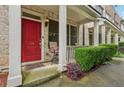 Inviting covered front porch with red door, chair seating, and manicured green hedges at 190 Marion Ne Pl, Atlanta, GA 30307