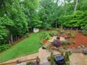A tiered backyard features mature trees, a storage shed, landscaping, and a paver patio at 2263 Hill Creek Way, Marietta, GA 30062