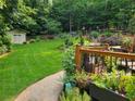 This landscaped backyard features mature trees, a storage shed, stone pavers, and a deck at 2263 Hill Creek Way, Marietta, GA 30062