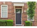 Close-up of a brick townhome's front door with a covered entrance and neatly trimmed bushes at 306 Masons Row, Marietta, GA 30060