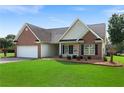Inviting single-story home with brick and siding, a two-car garage, and a well-kept lawn at 16 Kentucky Ne Walk, Cartersville, GA 30121