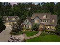 Aerial shot showcasing the home's elegant architecture, manicured lawn, and the convenience of a detached three-car garage at 193 Stonegate Trl, Carrollton, GA 30116