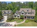 Expansive aerial view of the property with lush landscaping, a welcoming front porch, and a detached three-car garage at 193 Stonegate Trl, Carrollton, GA 30116