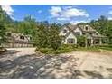 Charming two-story home with a detached garage and a driveway surrounded by greenery at 193 Stonegate Trl, Carrollton, GA 30116