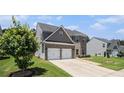 Charming two-story home with a two-car garage, manicured lawn and lush green tree at 210 Kestrel Cir, Covington, GA 30014