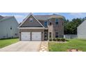 Charming two-story home with a two-car garage, brick facade, manicured lawn and stone pathway at 210 Kestrel Cir, Covington, GA 30014