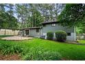 A backyard featuring a patio area surrounded by lush greenery and trees, creating a private outdoor space at 3408 Chestnut Dr, Doraville, GA 30340
