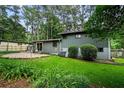 Lovely backyard with a patio area, lush green lawn, and mature trees providing shade at 3408 Chestnut Dr, Doraville, GA 30340