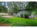 Large backyard with a patio area, lush green grass, and plenty of trees at 3408 Chestnut Dr, Doraville, GA 30340