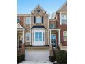 Beautiful townhome exterior with brick, columns, shutters, and a well-maintained front yard at 1286 Creekside Se Ter, Smyrna, GA 30082
