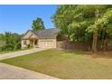 Charming home features a manicured lawn and a two-car garage at 3792 Refinement Way, Douglasville, GA 30135