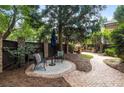 Landscaped backyard with patio, stone walkway, fireplace, and an umbrella that provides shade for a relaxing outdoor space at 625 Society St, Alpharetta, GA 30022
