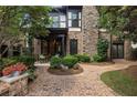 Beautiful backyard featuring a brick patio, stone accents, walkway, and lush landscaping around the perimeter at 625 Society St, Alpharetta, GA 30022