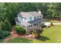 Aerial view of a two-story home featuring a covered front porch, complemented by mature trees and landscaped grounds at 226 Nacoochee Dr, Woodstock, GA 30188