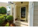 Close-up of the front door, featuring a glass pane, sidelights, and a well-manicured landscape at 306 Burdock Trce, Woodstock, GA 30188