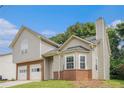 Charming two-story home with a brick-accented foundation, siding, arched window and well-manicured lawn at 4400 Old Allgood Cir, Stone Mountain, GA 30083