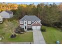 Aerial view of a two-story brick home with a two-car garage and well-maintained landscaping at 3224 Wolf Club Sw Ln, Atlanta, GA 30349
