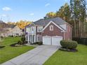 Charming two-story home with a manicured lawn, two-car garage, and classic brick facade at 3224 Wolf Club Sw Ln, Atlanta, GA 30349
