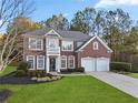 Attractive two-story brick home featuring a two-car garage, front lawn and meticulous landscaping at 3224 Wolf Club Sw Ln, Atlanta, GA 30349