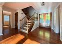 Warm and inviting foyer featuring hardwood floors, staircase, and decorative glass-paneled doors at 8710 Mount Rushmore Dr, Johns Creek, GA 30022