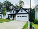 Stunning home with a two-car garage, white siding, black trim, and a newly poured concrete driveway at 1540 Ox Bridge Ct, Lawrenceville, GA 30043