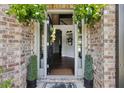 Inviting entryway featuring a decorative front door, brick accents and decorative plants at 3126 Cove View Ct, Dacula, GA 30019