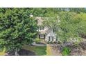 Beautiful two-story home with lush green trees, well-maintained landscaping, and inviting curb appeal at 300 Windsor Chase Trl, Johns Creek, GA 30097