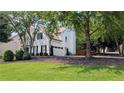 Well-maintained home with a visible two-car garage, set on a neatly kept lawn with mature trees at 300 Windsor Chase Trl, Johns Creek, GA 30097
