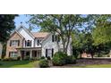 Inviting two-story home featuring a combination of stone and siding, complemented by lush greenery at 300 Windsor Chase Trl, Johns Creek, GA 30097