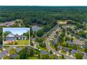 Aerial view showcases the home's location within a community surrounded by trees and a pond at 1055 Kibbe Cir, Lawrenceville, GA 30044