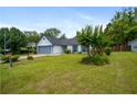 Well-kept single-story home featuring lush green lawn, a gray garage door, and nice landscaping at 1055 Kibbe Cir, Lawrenceville, GA 30044
