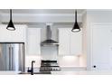 Well-equipped kitchen with stainless steel appliances, white cabinets, modern lighting, and stylish backsplash at 1110 Bakary Ct, Decatur, GA 30032