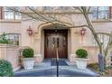 Elegant entrance to the building featuring double doors, classic architecture, and manicured potted greenery at 1717 N Decatur Ne Rd # 117, Atlanta, GA 30307